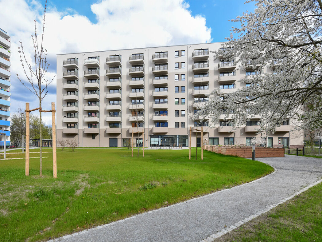 Außenansicht degewo-Neubau Venusstraße 28 mit Grünflächen und Weg im Vordergrund.