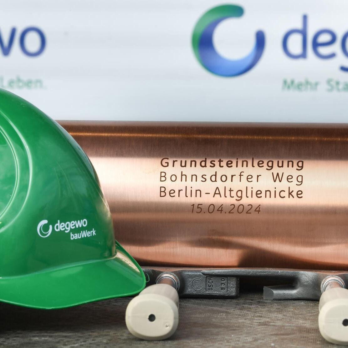 Bauhelm von bauWerk und Schatulle der Grundsteinlegung vom Klimahaus, davor liegen 3 Hammer.