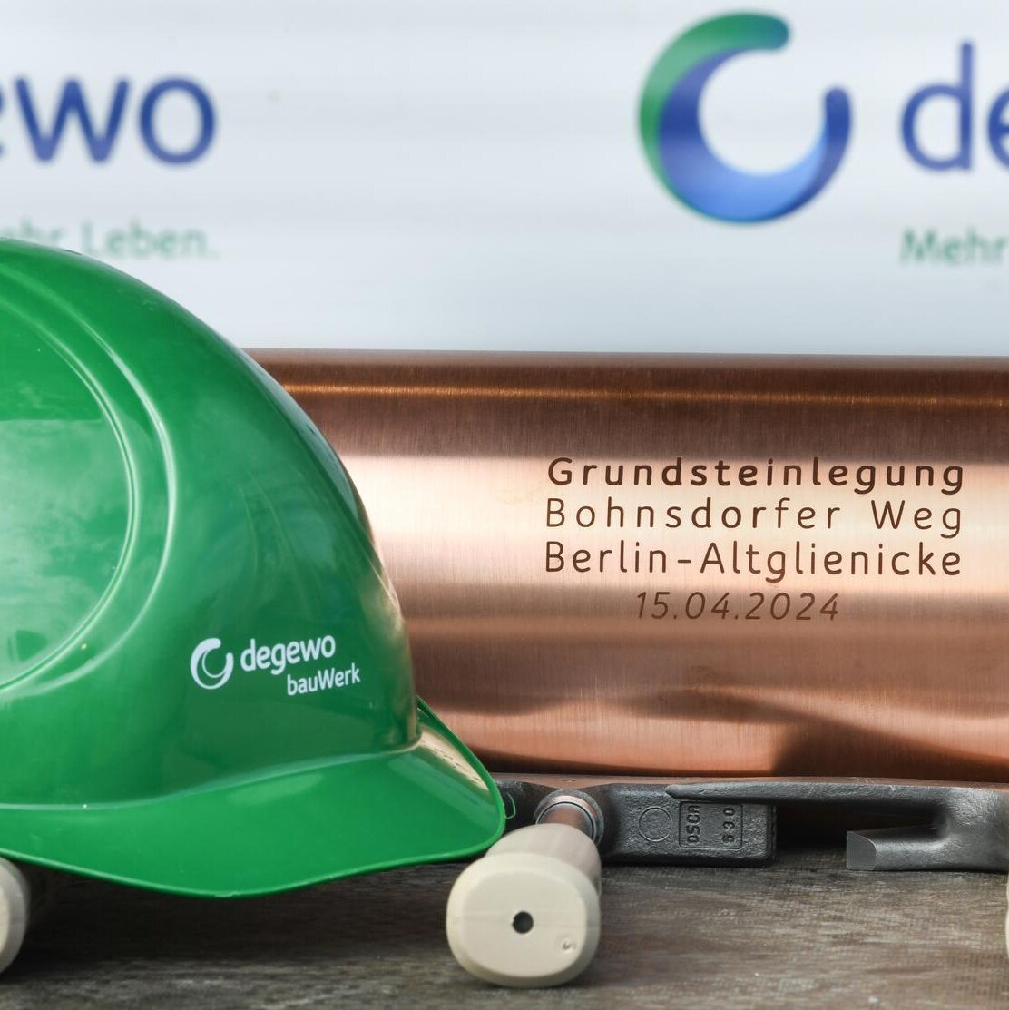 Bauhelm von bauWerk und Schatulle der Grundsteinlegung vom Klimahaus, davor liegen 3 Hammer.