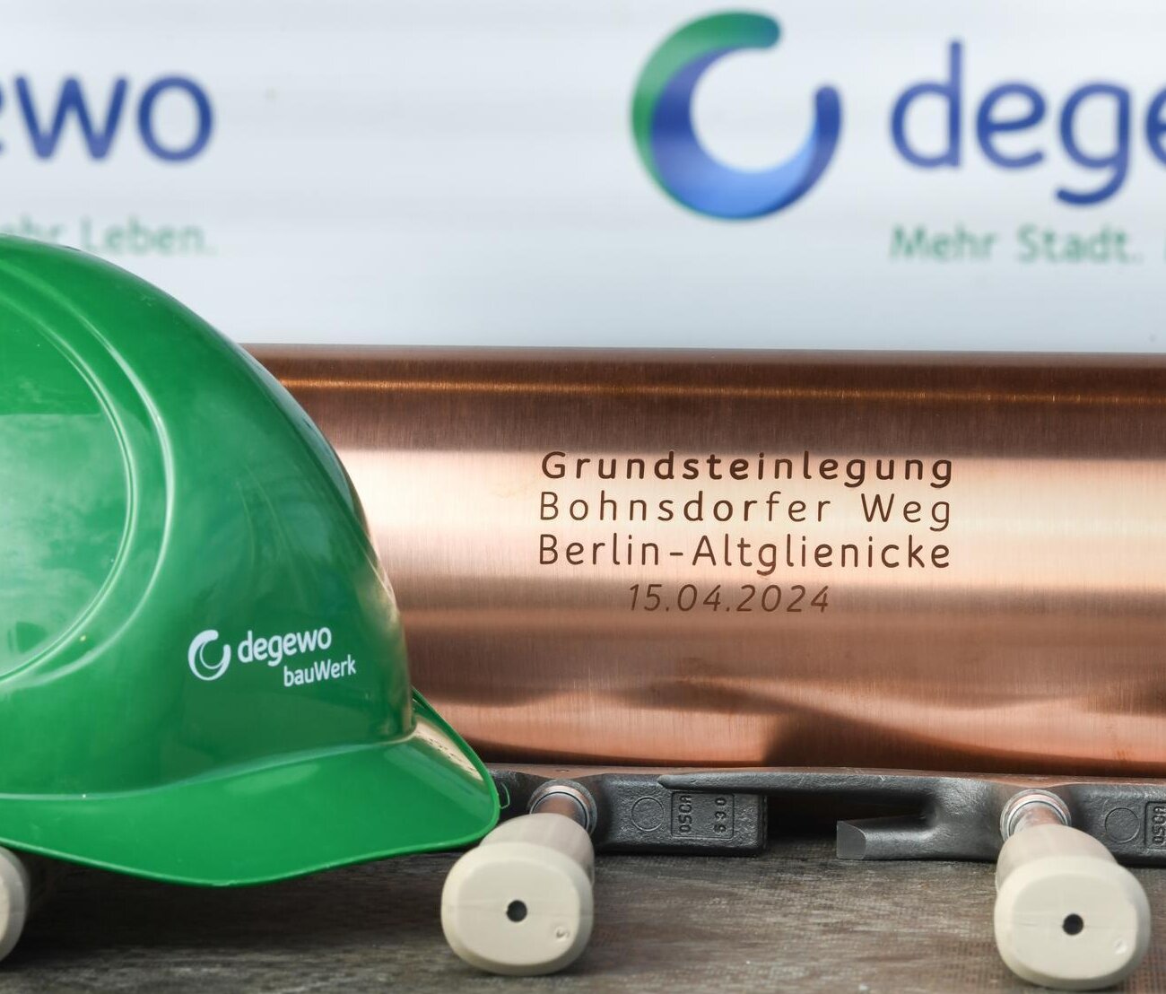 Bauhelm von bauWerk und Schatulle der Grundsteinlegung vom Klimahaus, davor liegen 3 Hammer.