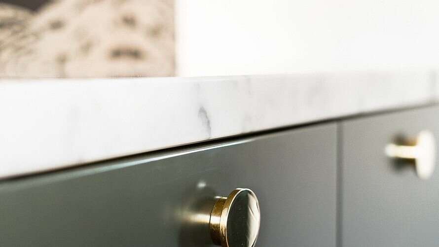 Graue Küchenschublade mit metallfarbenen runden Griff