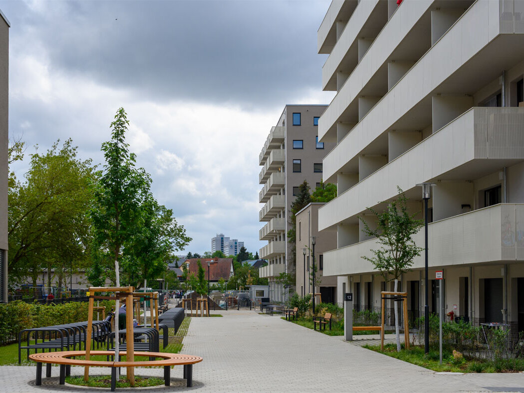 Außenansicht degewo-Neubau Karl-Holtz-Straße 2 bis 8 mit Sitzgruppe im Vordergrund.