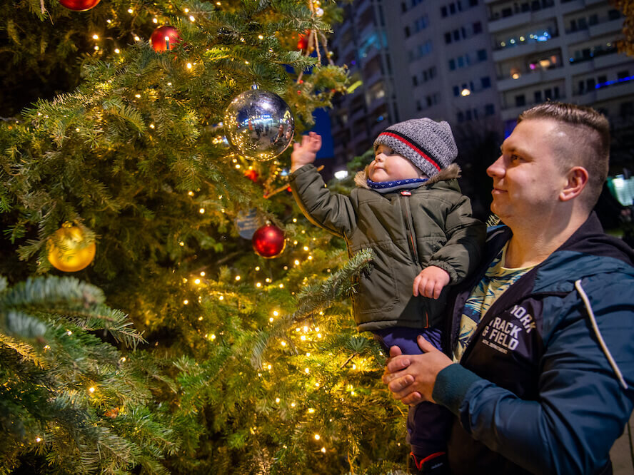 Vater und Sohn schmücken den Weihnachtsbaum