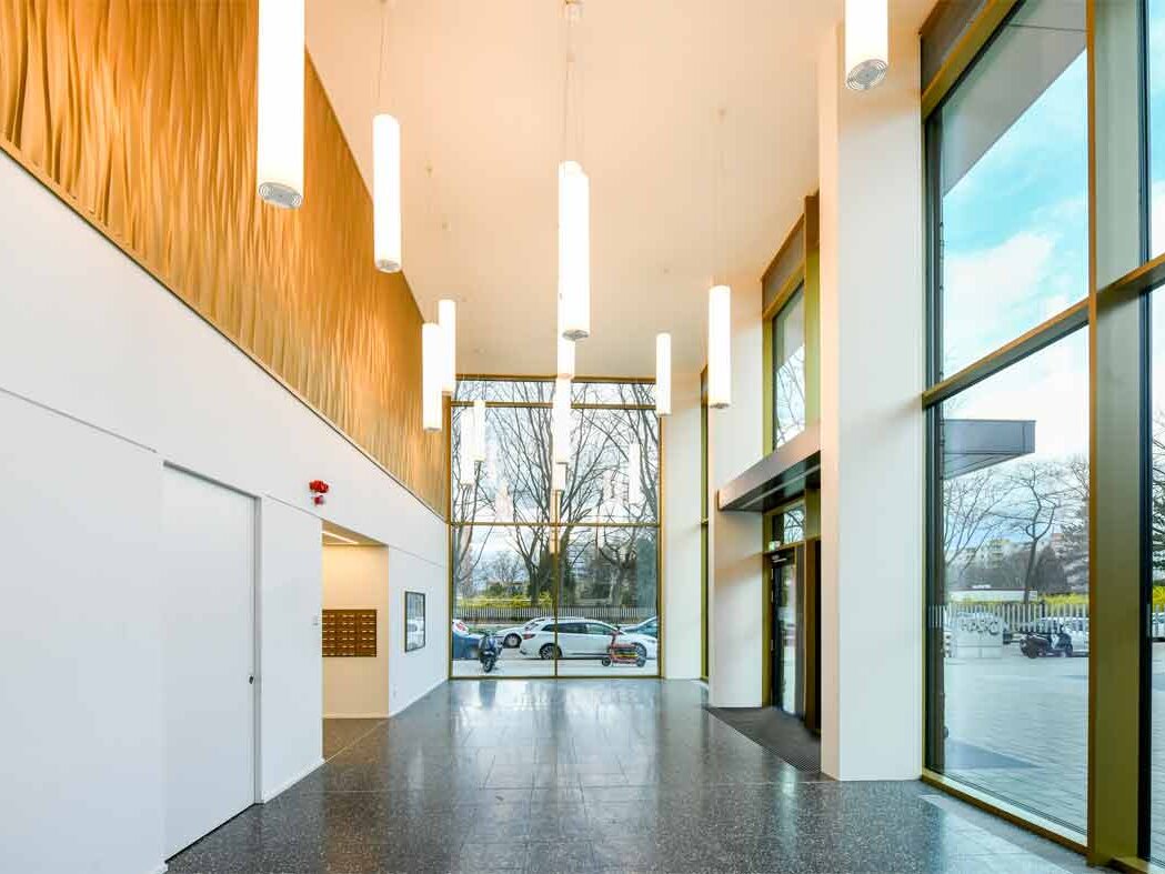 Innenansicht degewo-neubau Friedrich-Kayßler-Weg 1: beleuchteter Eingangsbereich mit Glasfront.