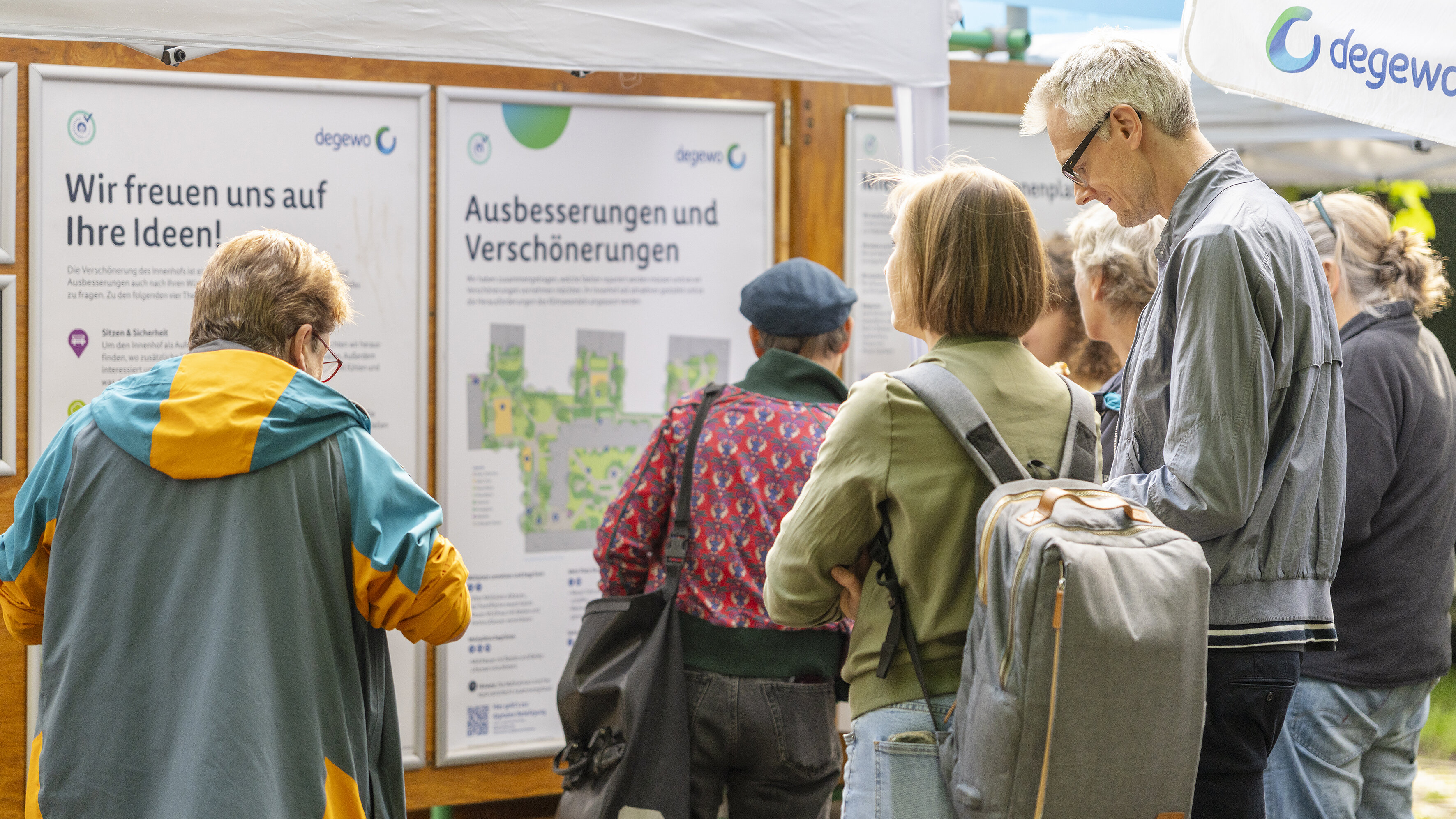 Menschen informieren sich an Tafeln zu Umgestaltungsideen.
