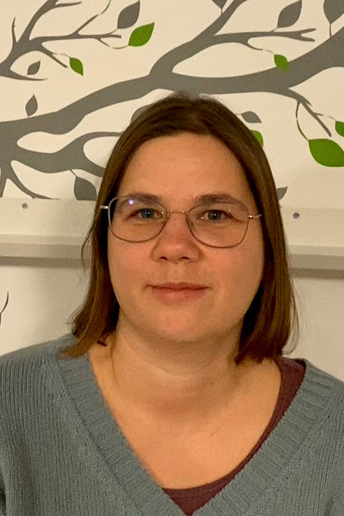 Porträt Laura Friedel, eine Frau mit halblangen Haaren und Brille.