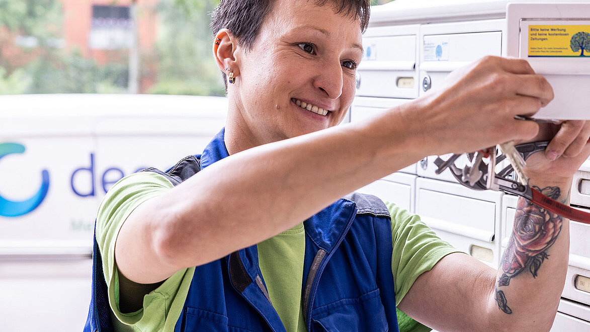 Hausmeisterin repariert Briefkastenschloss