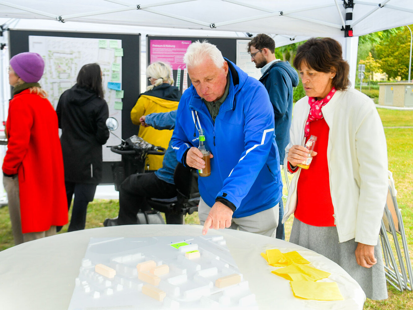 Zwei Personen schauen sich ein Modell an, das auf einem Tisch steht.