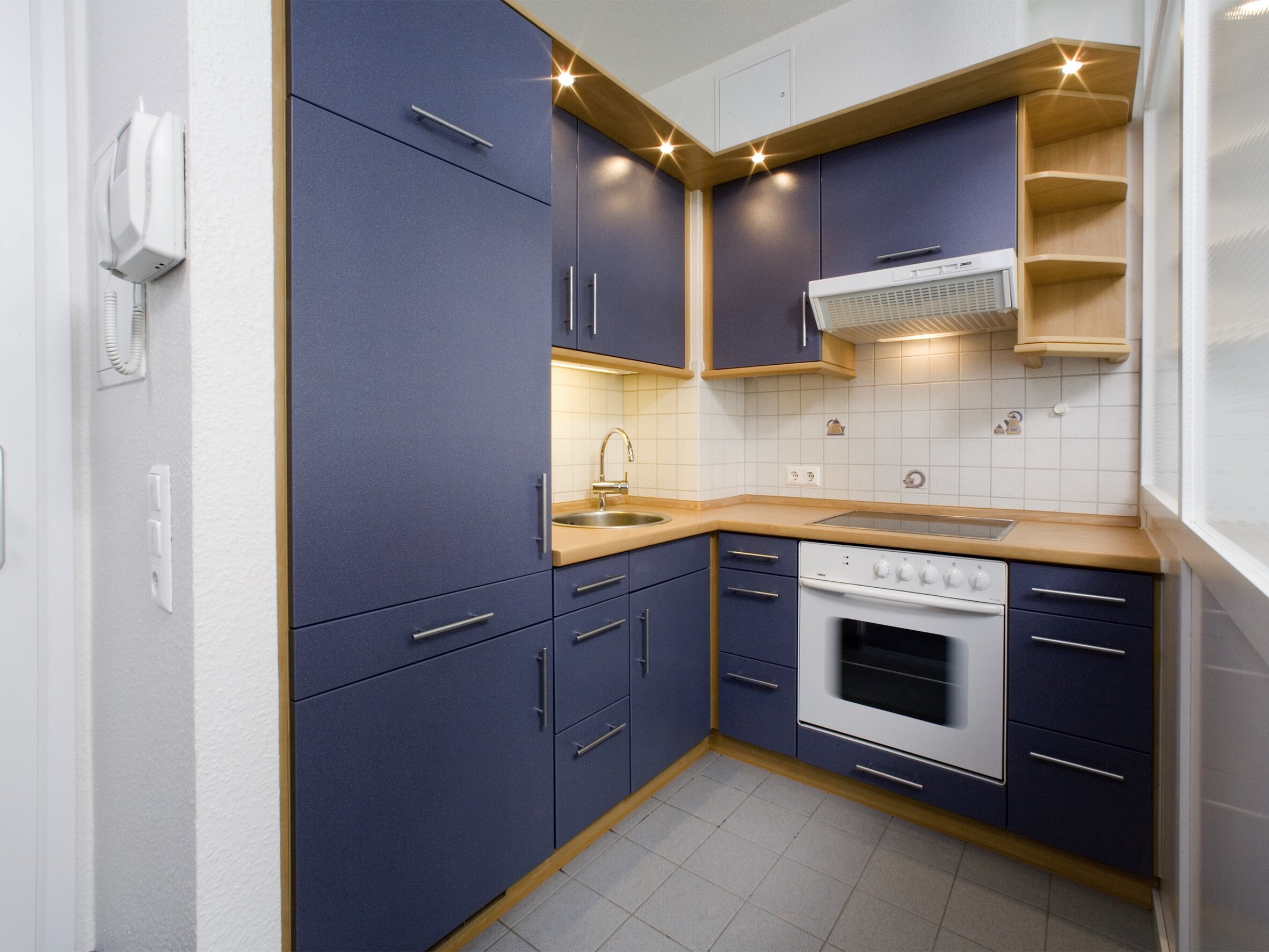 Blick in die kleine Küche mit blauen Schränken
