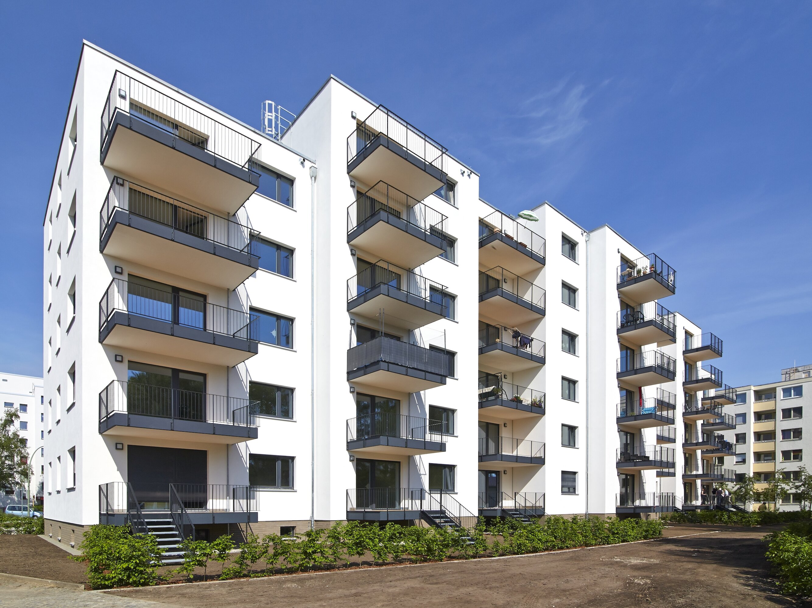 Außenansicht degewo-Neubau Waldsassener Straße 51: Hofseite mit Weg im Vordergrund.