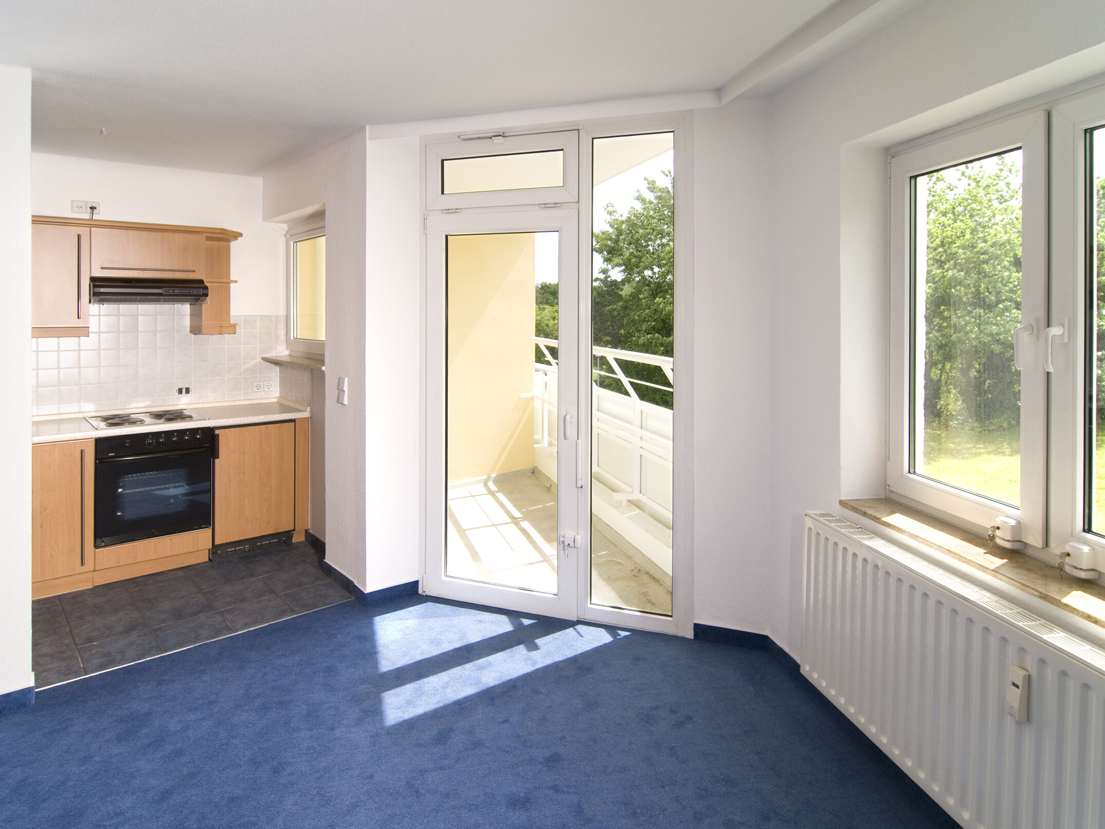 Wohnraum mit Küchenzeile und Balkontür