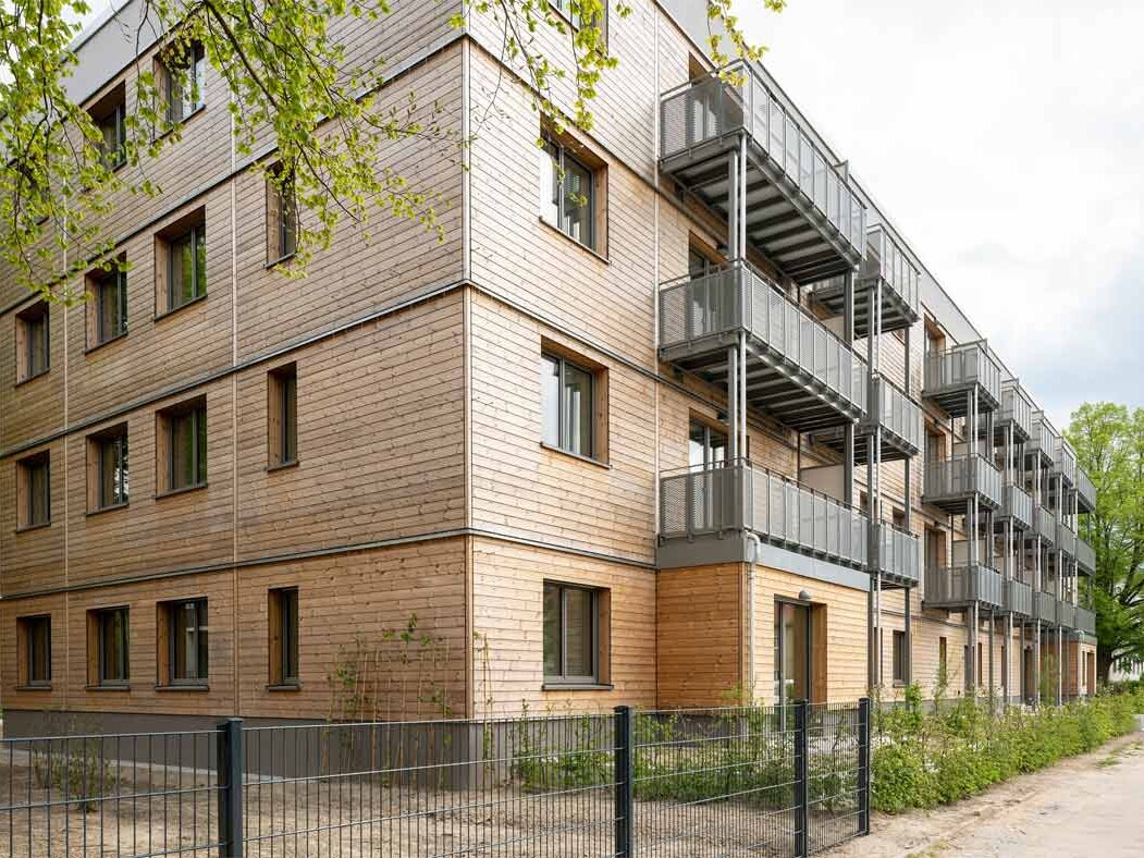 Außenansicht degewo-Neubau Beyrodtstraße 52 mit Zaun und Weg im Vordergrund.