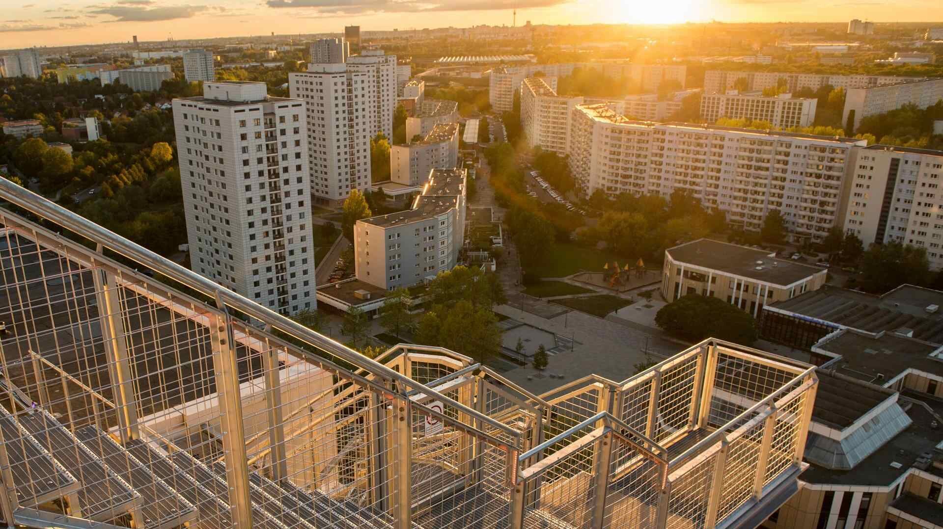 Aussicht von der Plattform des skywalk mit Ausblick auf die Marzahner Promenade. Die Sonne geht unter, weit hinten ist der Fernsehturm zu sehen.