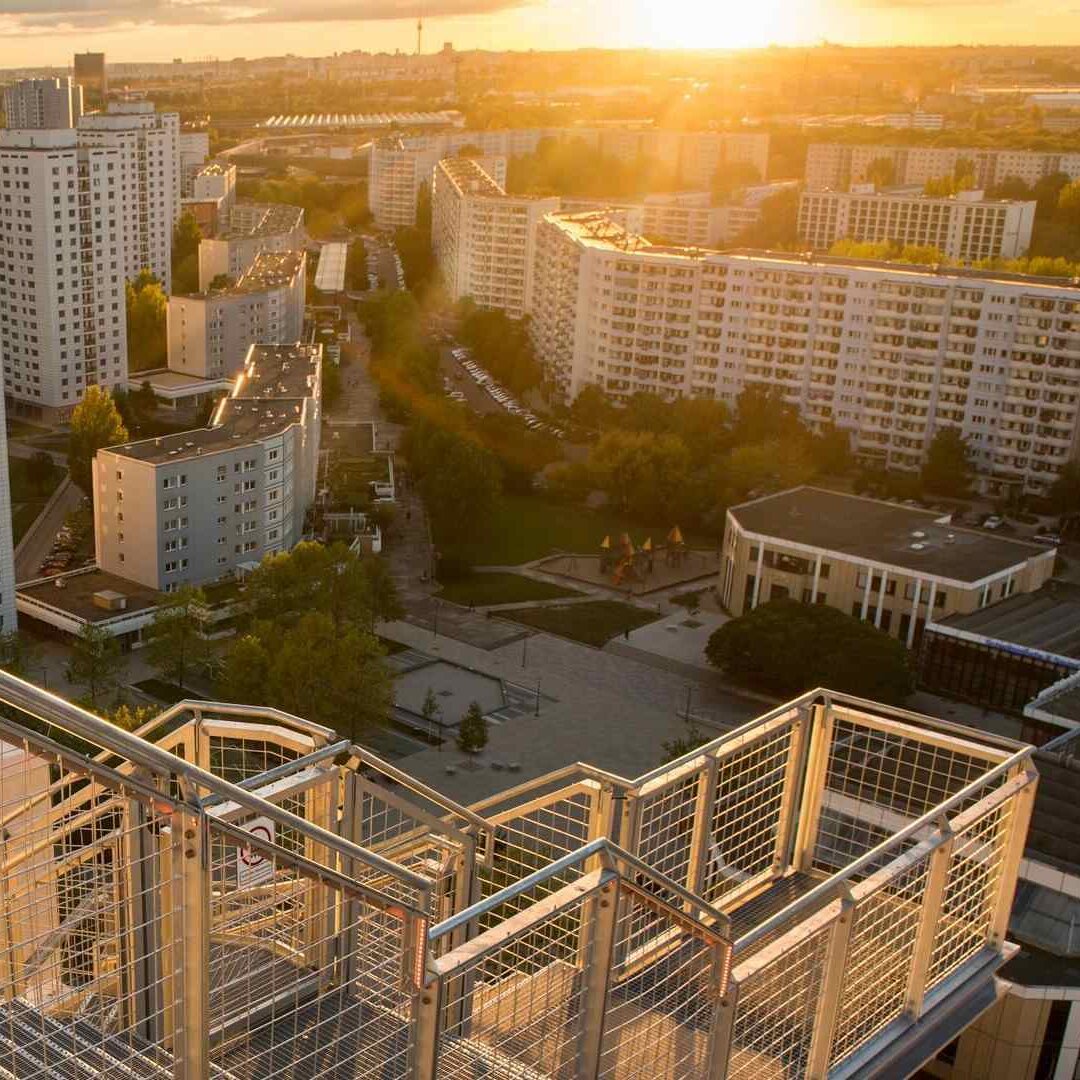 Aussicht von der Plattform des skywalk mit Ausblick auf die Marzahner Promenade. Die Sonne geht unter, weit hinten ist der Fernsehturm zu sehen.