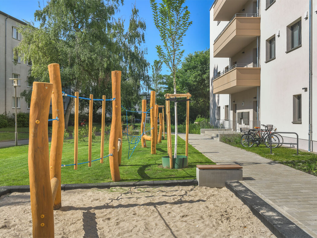 Außenansicht degewo-Neubau Ottomar-Geschke-Straße mit Spielplatz im Vordergrund.