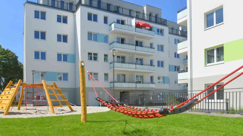 Außenansicht degewo-Ankauf Pepitahöfe: Hofseite mit Spielplatz im Vordergrund.