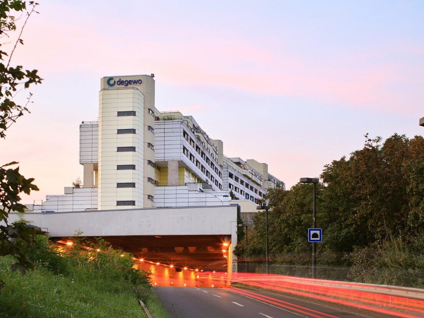 Blick auf einen großen Wohnkomplex mit weißen Platten an den Außenwänden und der Aufschrift degewo