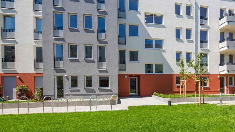 Außenansicht degewo-Neubau Elly-Heuss-Knapp-Straße 46 mit Rasenfläche im Vordergrund.