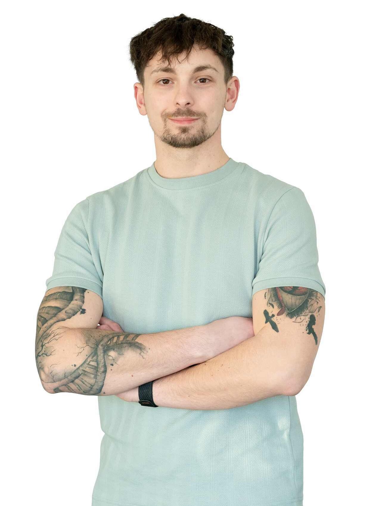 Portrait des Mieterbeirates Nick Hörsejau. Er trägt ein grünes Shirt, hat die Arme vor der Brust verschränkt und schaut in die Kamera.