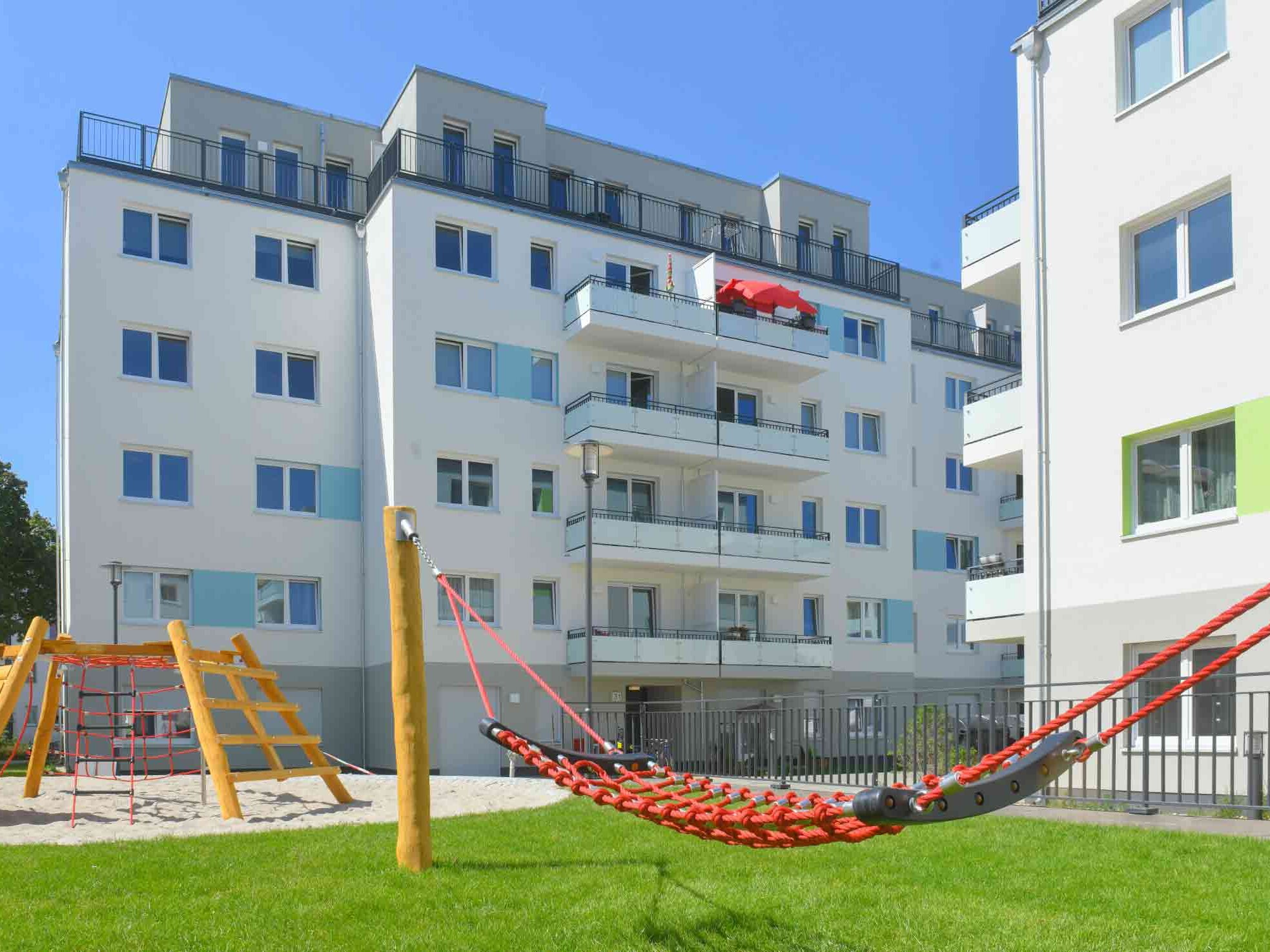 Außenansicht degewo-Ankauf Pepitahöfe: Hofseite mit Spielplatz im Vordergrund.