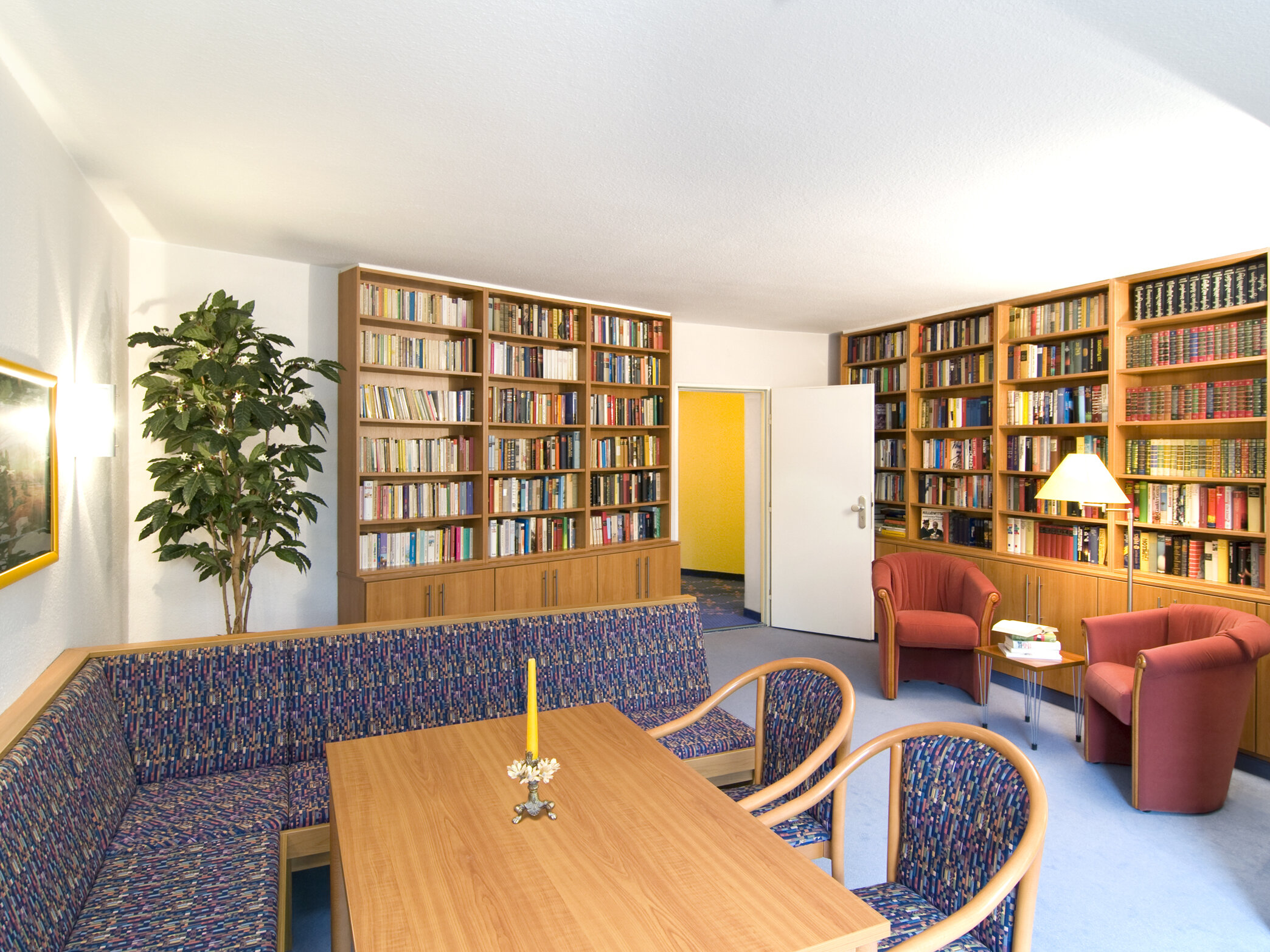 Ein Innenraum mit Teppich, Bücherregalen und einem Esstisch.