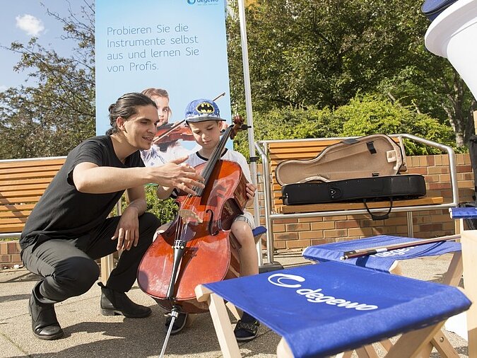 Ein Musiker zeigt Kindern sein Cello
