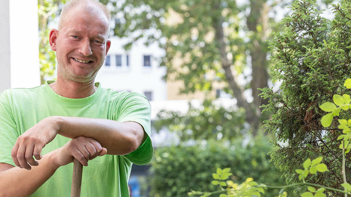Gärtner steht vor grüner Hecke