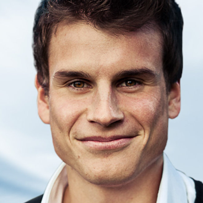 Portraitfoto von Steven Schmeling. Ein Mann blickt freundlich in die Kamera, er trägt ein weißes Hemd und eine schwarze Jacke.