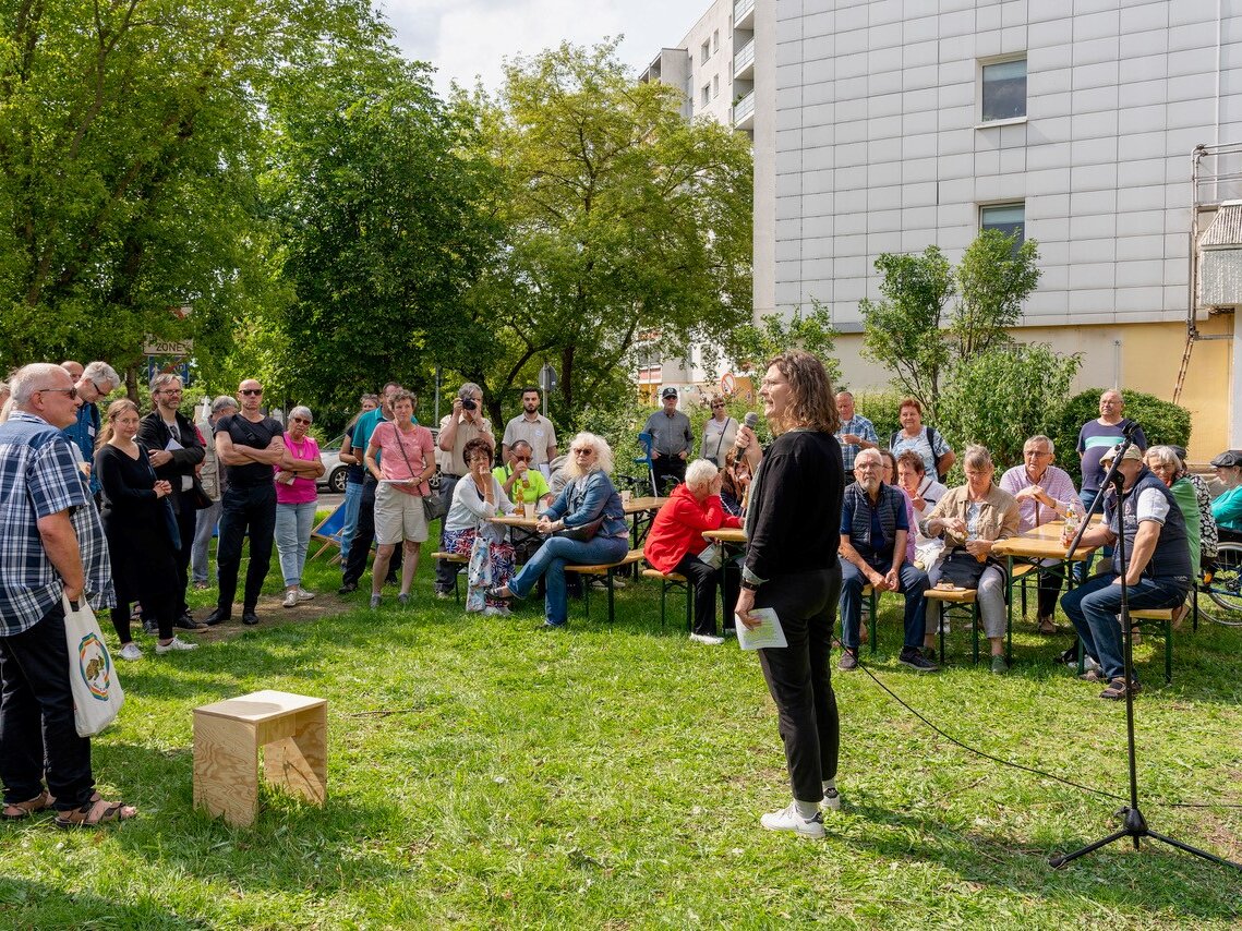Referentin spricht bei einer Informationsveranstaltung im Quartier Marzahn vor versammelten Mieterinnen und Mietern.