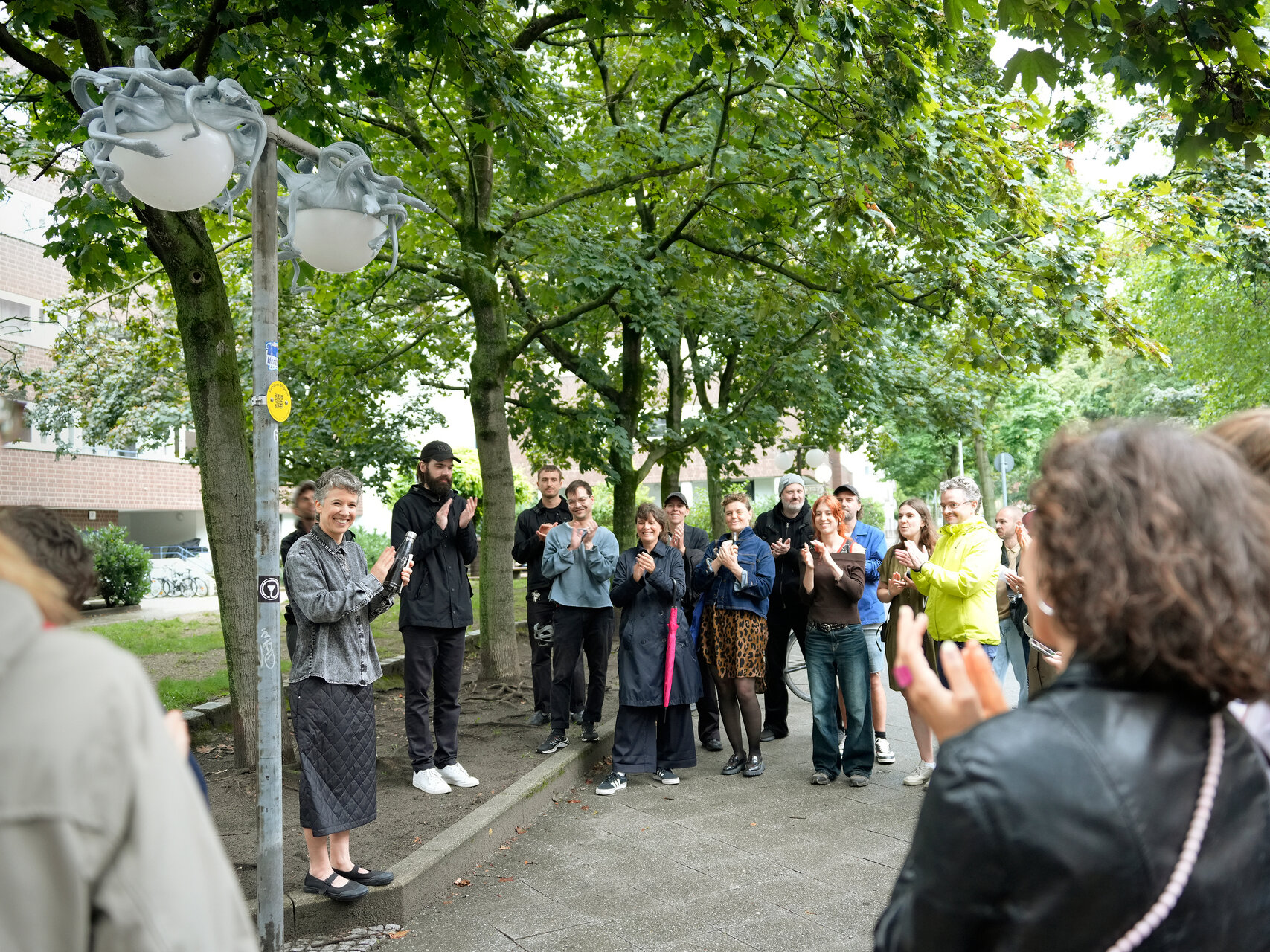 Das Publikum feiert die Eröffnung der Nightcaps. Die Künstlerin spricht zur Menge.