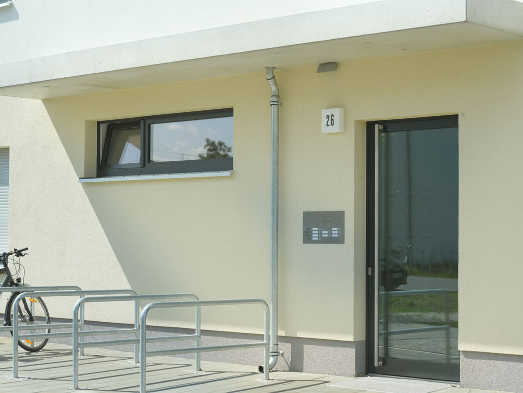 Außenansicht degewo-Neubau Wilhelm-Hoff-Straße 26: Eingangsbereich mit Fahrradständern.