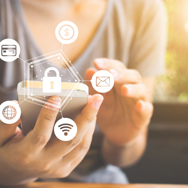 Person hält ein Smartphone in der Hand. Über dem Gerät sind Symbole für Sicherheit, WLAN, E-Mail, Kreditkarte und Internet mit einem Schloss dargestellt.