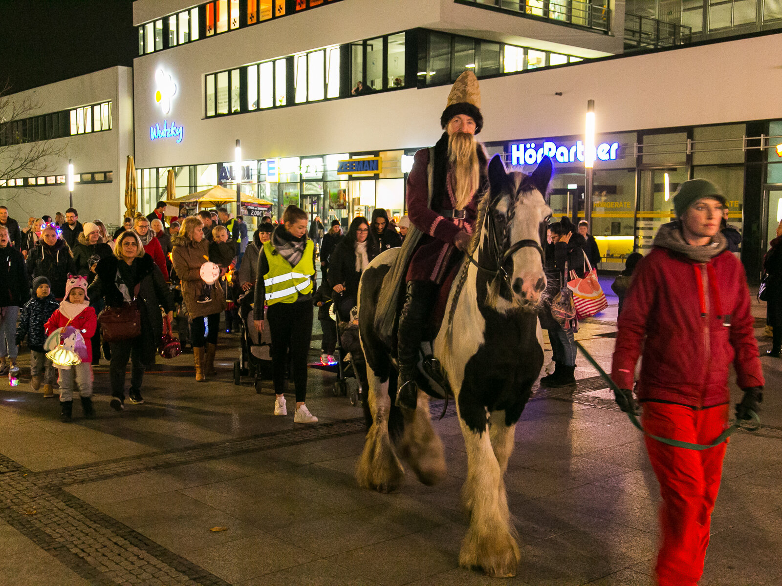 Auf dem St.Martins Umzug wird ein Pferd geführt und Menschen mit Laternen folgen