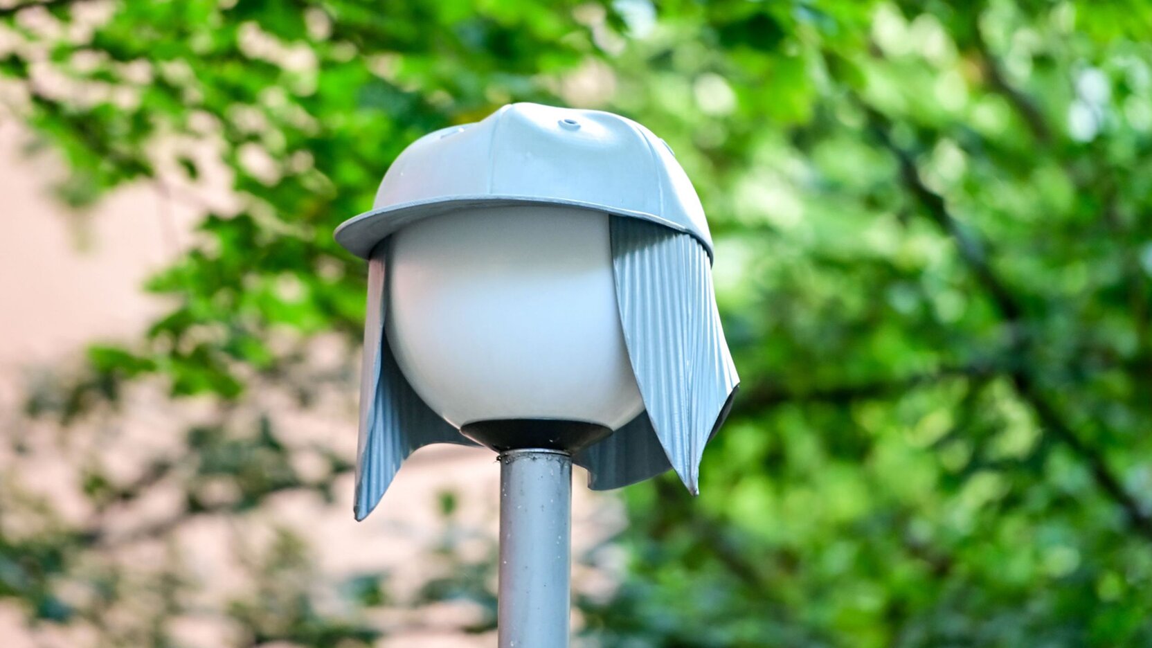 Eine sogenannte Nightcap-Lampe ist im Vordergrund zu sehen und Baumzweige verschwommen im Hintergrund.