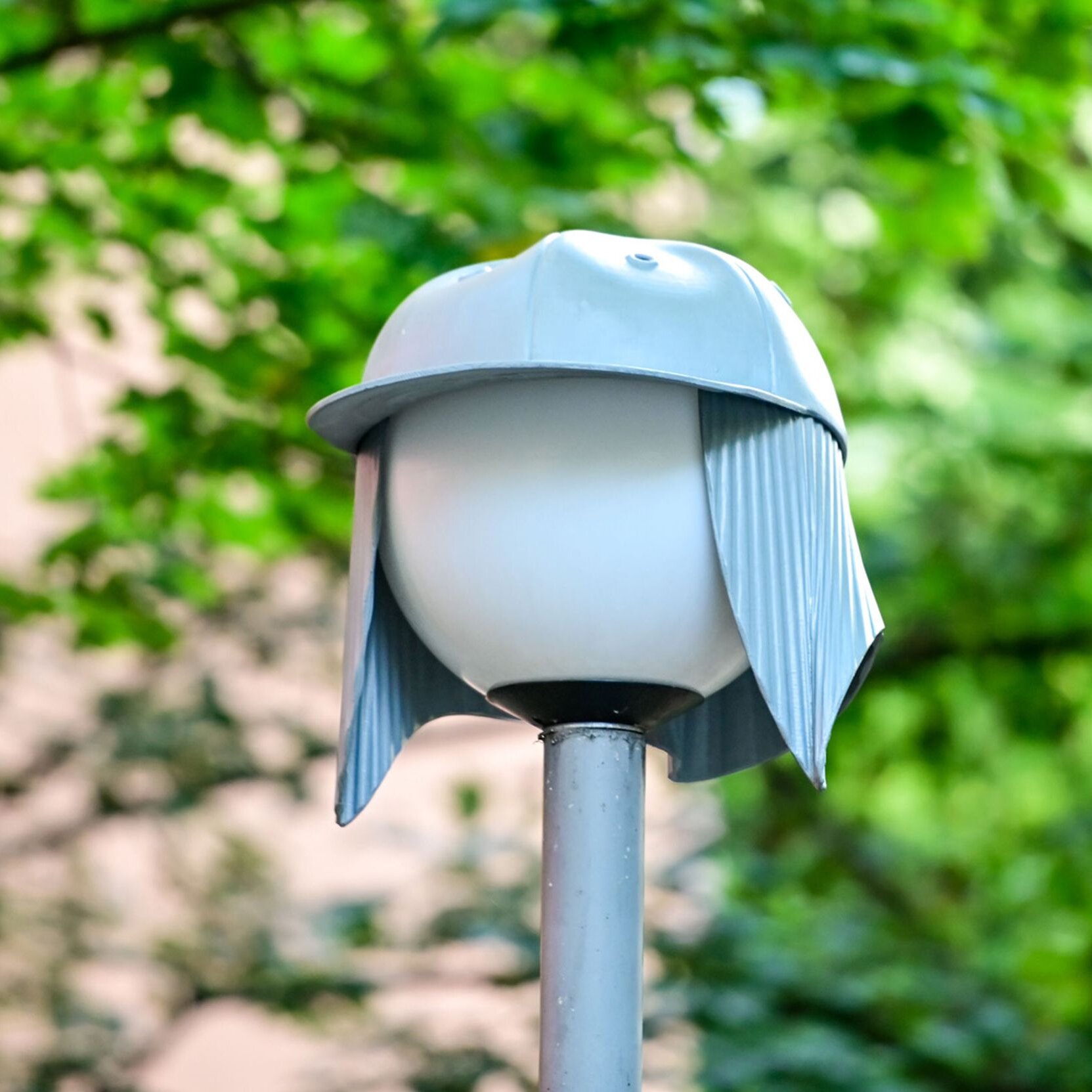 Eine sogenannte Nightcap-Lampe ist im Vordergrund zu sehen und Baumzweige verschwommen im Hintergrund.