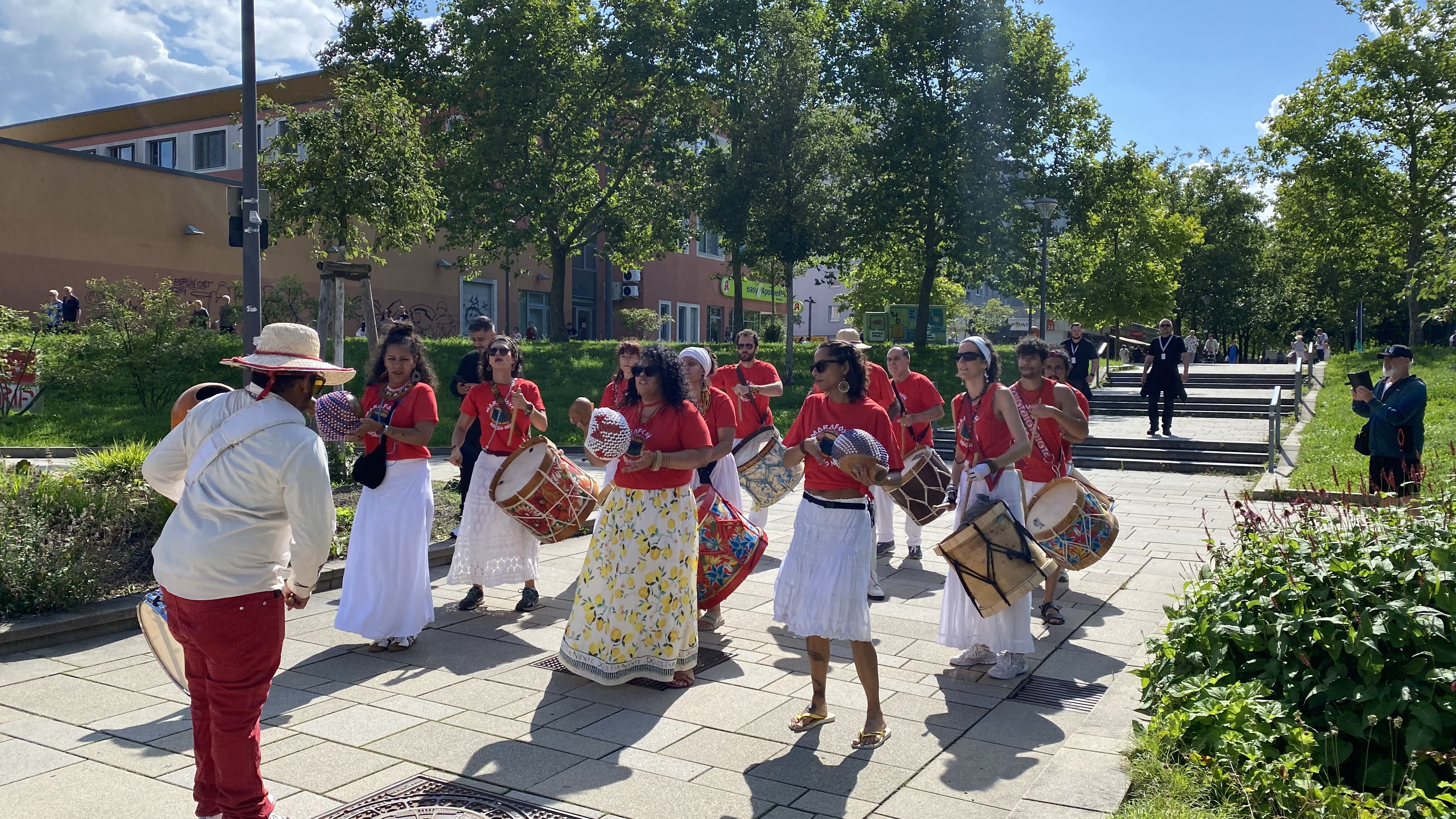 Musikgruppe spielt Trommeln bei Straßenfest im Wohngebiet.