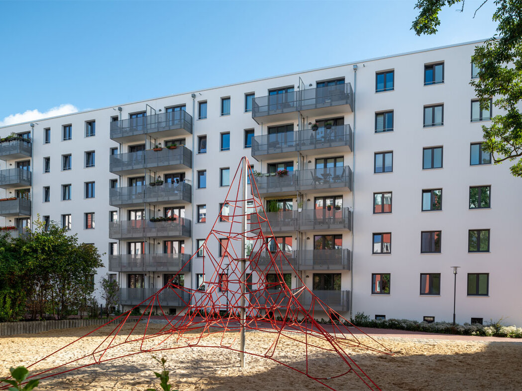 Außenansicht degewo-Neubau Lichtburgring: Hofseite mit Spielplatz im Vordergrund.