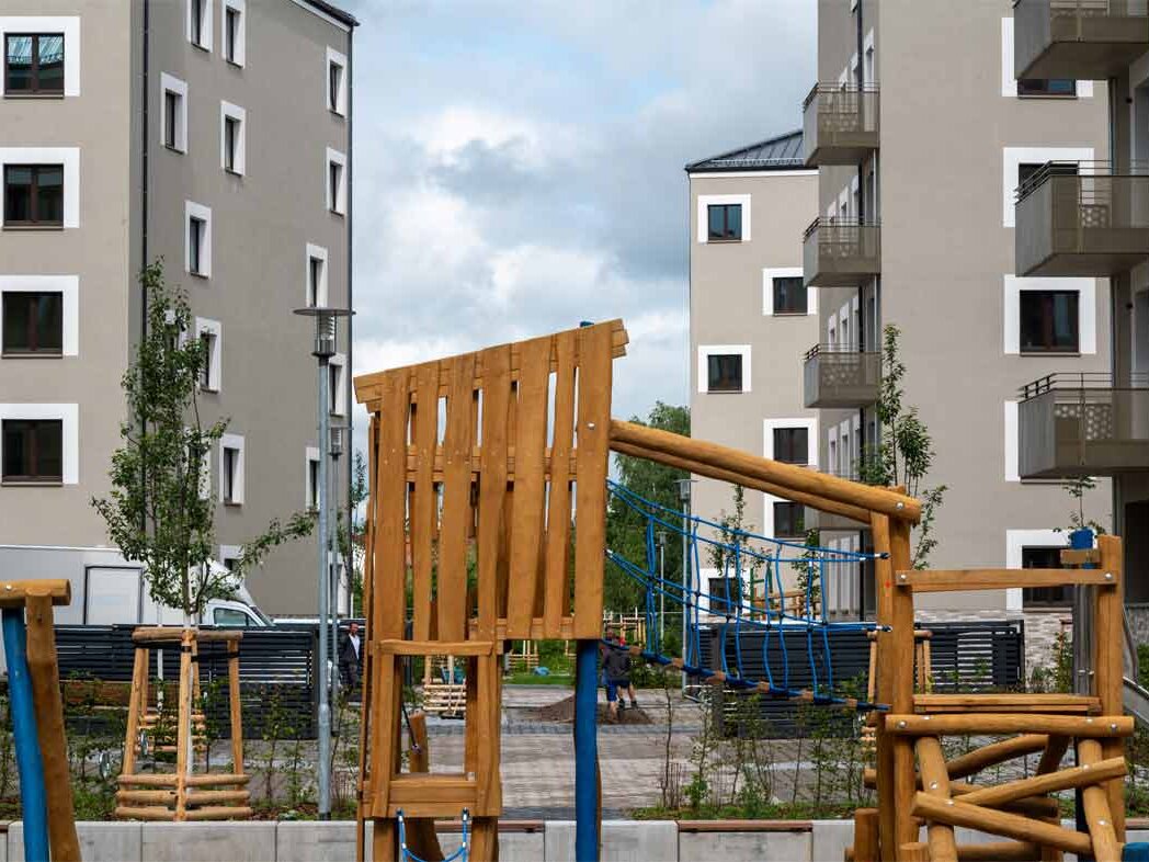 Außenansicht degewo-Neubau Falkenstraße Adlerstraße: Hofseite mit Spielplatz im Vordergrund.