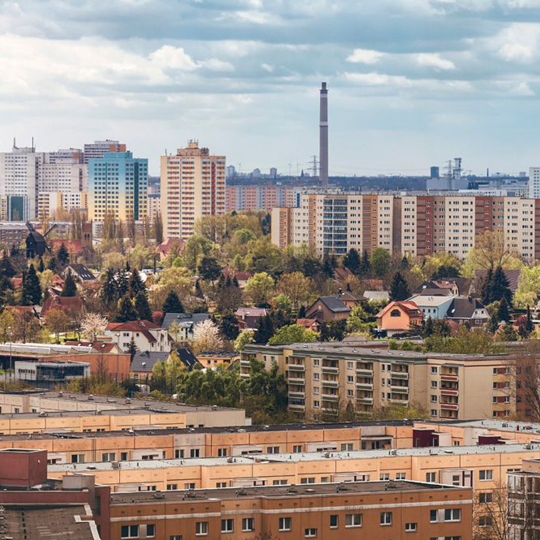 Panorama Blick auf eine Stadt mit Plattenbauten und Bäumen