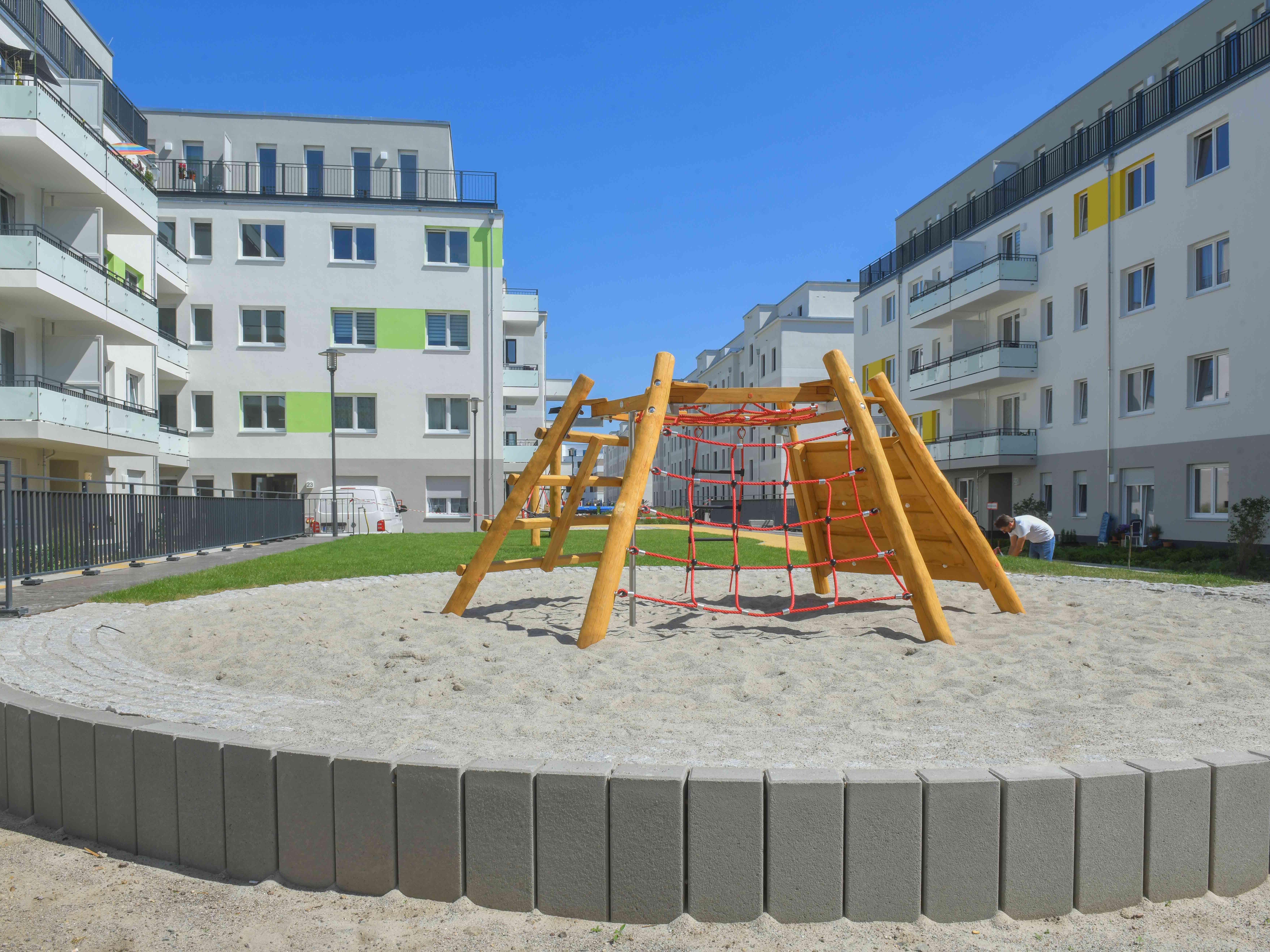 Außenansicht degewo-Ankauf Pepitahöfe: Hofseite mit Spielplatz im Vordergrund.
