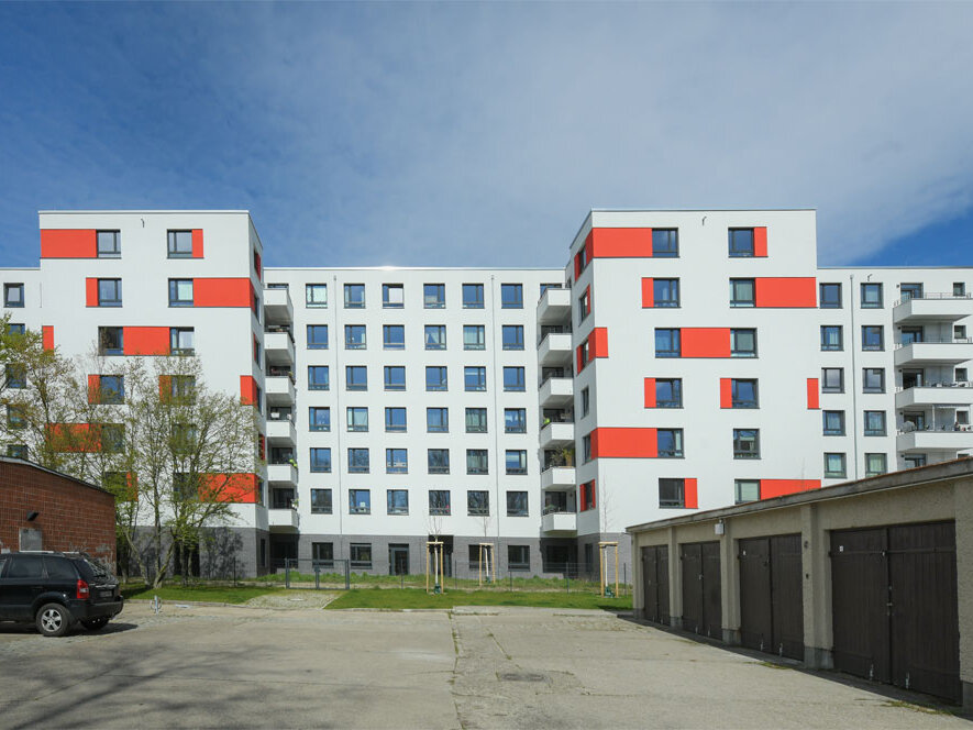 Außenansicht degewo-Neubau An der Wuhlheide 112 bis 116 mit Garagenareal im Vordergrund.