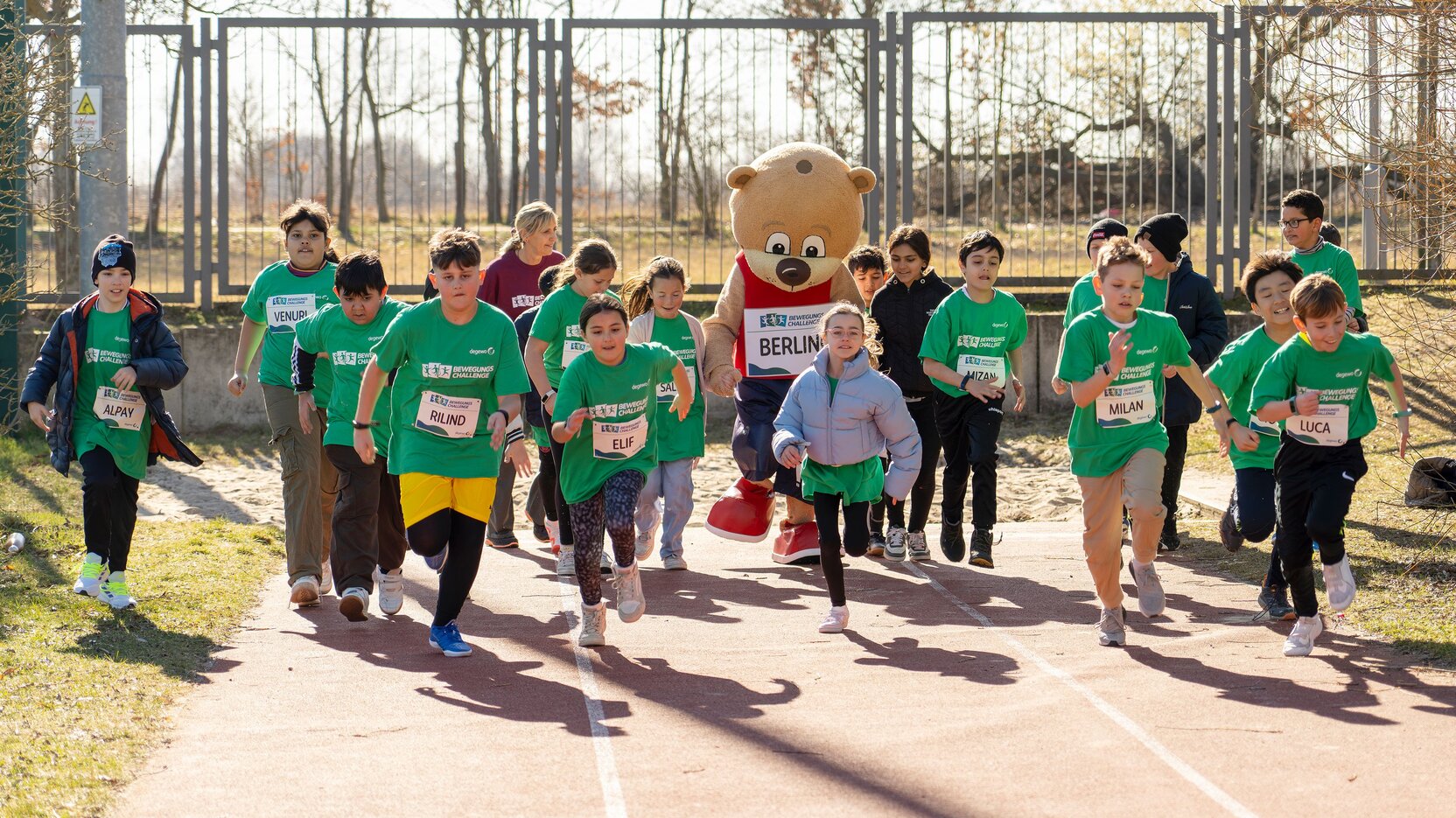 Eine Gruppe von Kindern mit Startnummer auf dem T-Shirt läuft los.