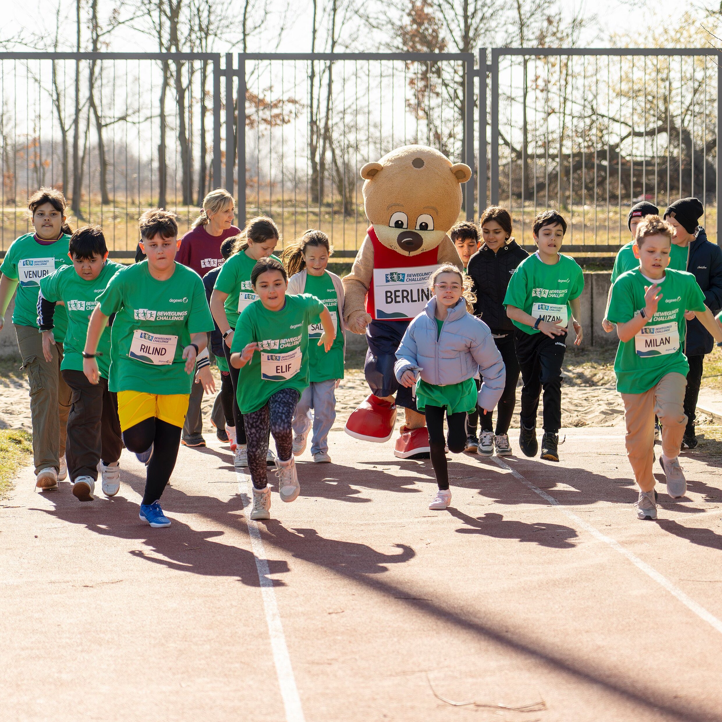 Eine Gruppe von Kindern mit Startnummer auf dem T-Shirt läuft los.