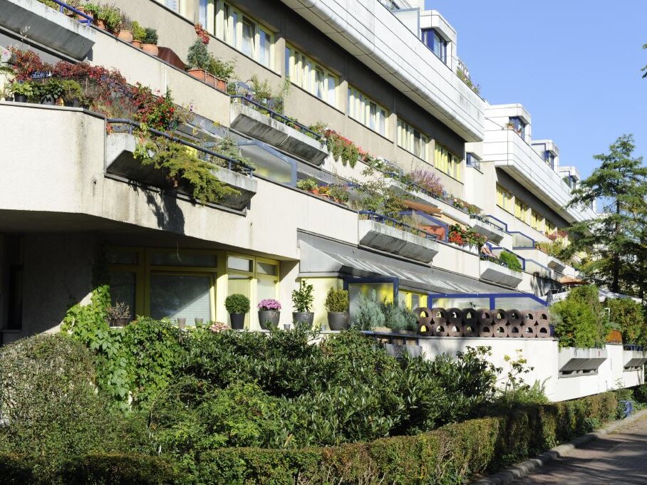 Bepflanzte Terrassen und Balkone der Wohnanlage „Die Schlange“ in Berlin-Schöneberg, mit üppigem Grün und individuellen Gartengestaltungen der Bewohnerinnen und Bewohner.