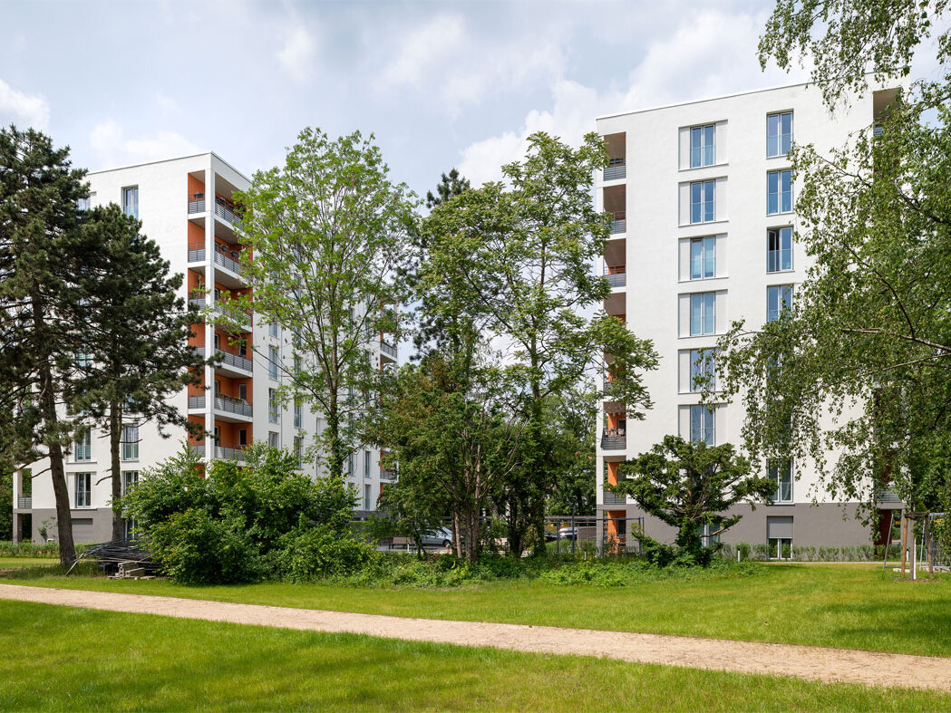 Außenansicht degewo-Neubau Ursulastraße 2 bis 4 mit Rasenflächen und Weg im Vordergrund.
