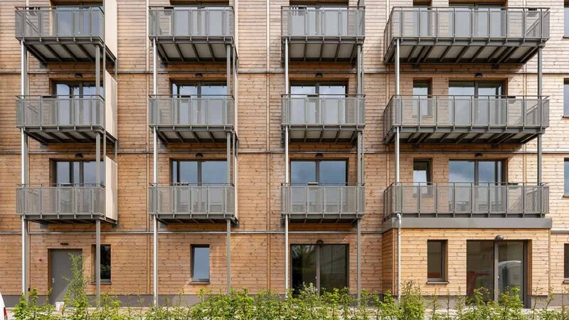 Außenansicht degewo-Neubau Beyrodtstraße 52 mit Sträuchern im Vordergrund.