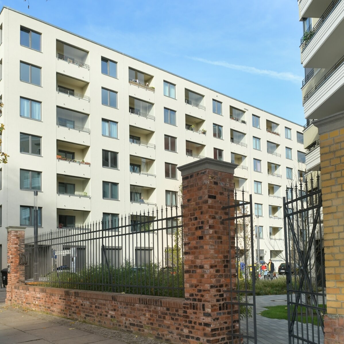 Außenansicht degewo-Neubau Klara-Franke-Straße 1 bis 7: Zufahrt mit Mauer und Zaun im Vordergrund.