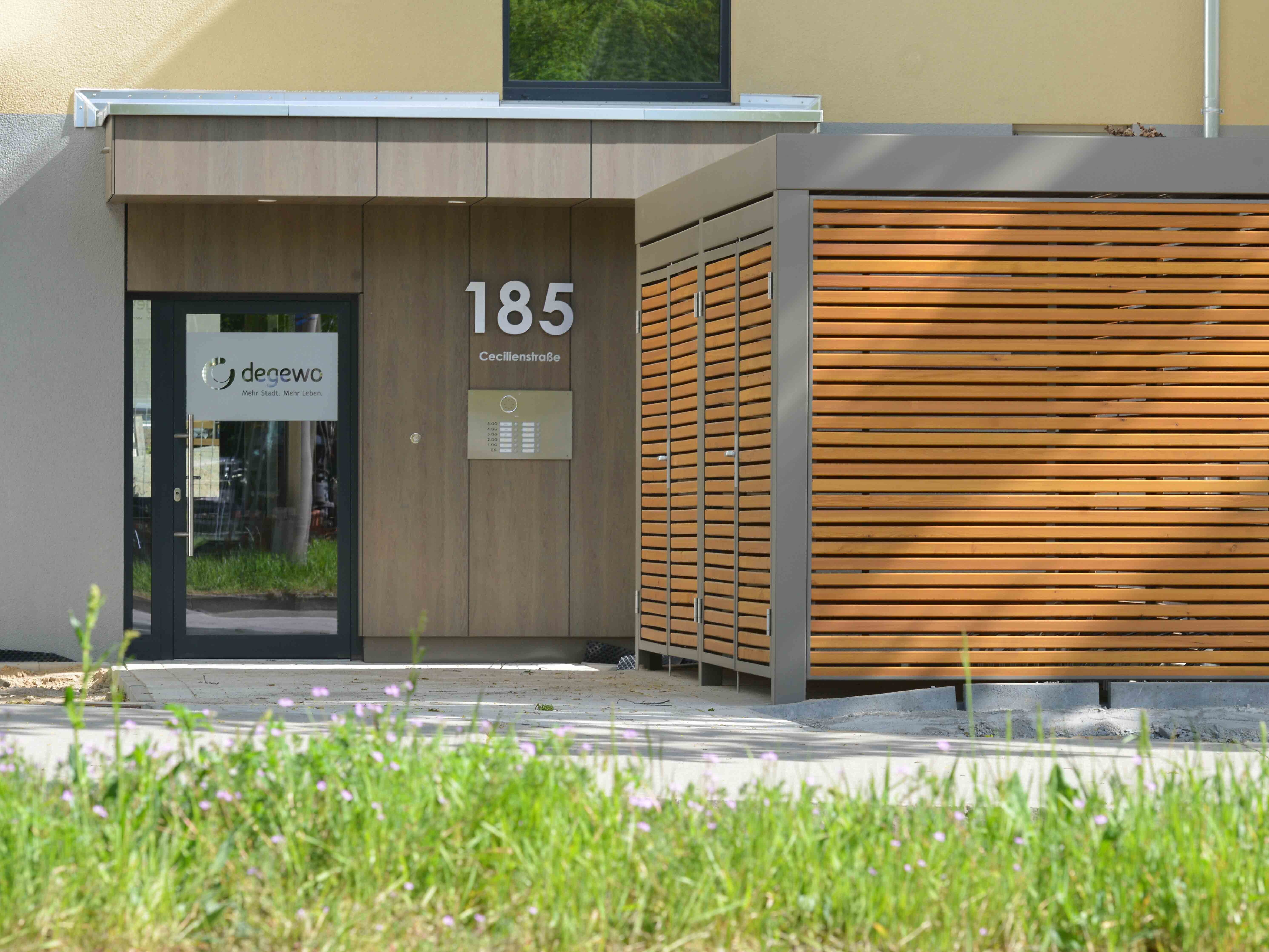 Außenansicht Eingangsbereich degewo-Neubau Joachim-Ringelnatz-Straße Cecilienstraße 185 mit Wiese im Vordergrund.