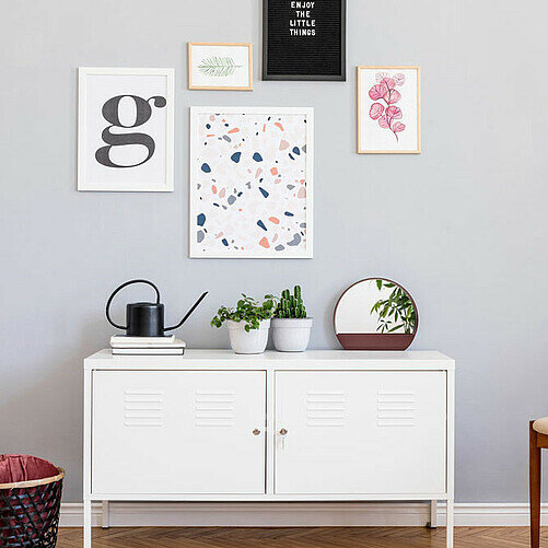 Bild zeigt Kommode und Bilder an der Wand