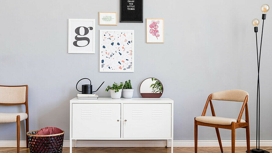 Bild zeigt Kommode und Bilder an der Wand